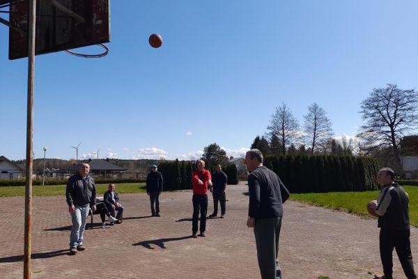 ieszkańcy grają w koszykówkę na terenie domu.