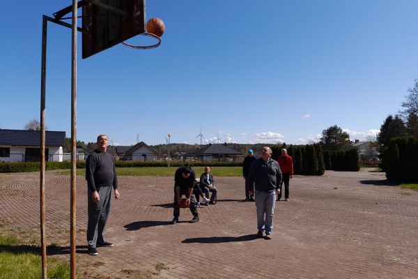 ieszkańcy grają w koszykówkę na terenie domu.