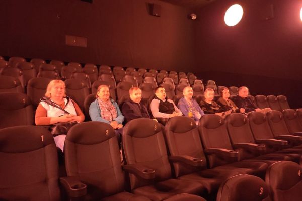 Mieszkańcy w sali kinowej podczaas seansu filmowego.