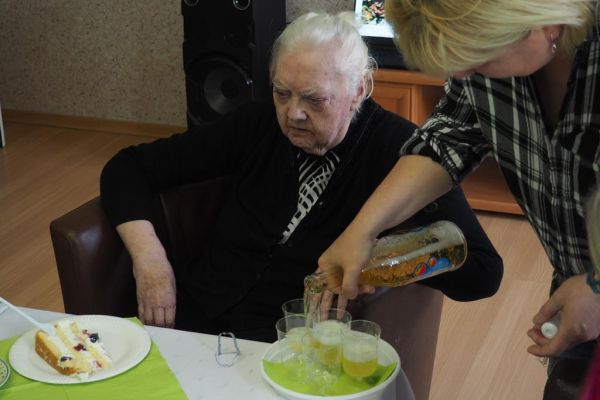 Terapeutka nalewa piccolo do literatek przy boku jubilatki.