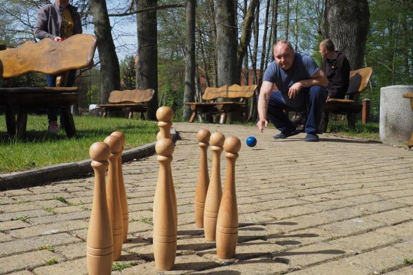 Mieszkaniec gra w kręgle na świeżym powietrzu podczas grillowania.