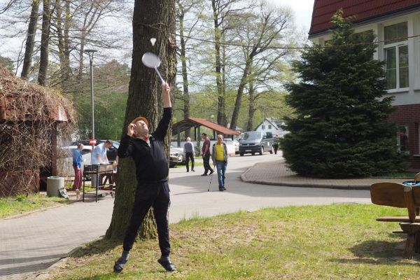 Mieszkaniec gra w badmintona podczas grilla.