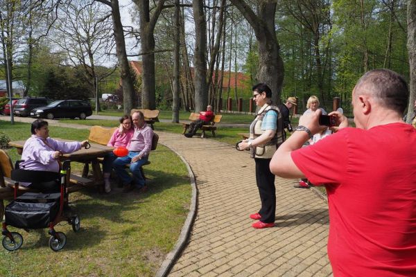 Mieszkaniecy grają w latajaca kulę na świeżym powietrzu podczas grillowania.