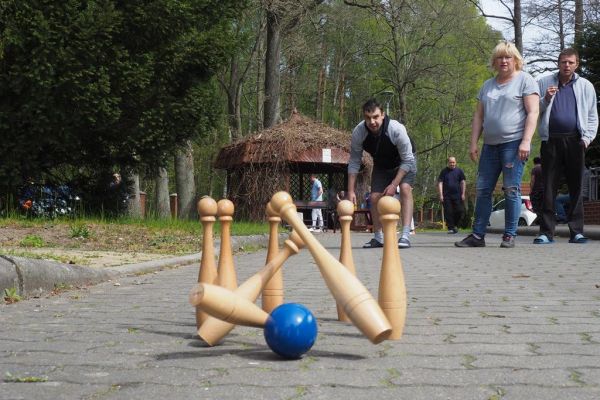 Mieszkaniec gra w kręgle na świeżym powietrzu podczas grillowania.