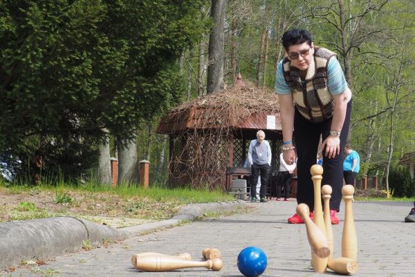 Mieszkanka gra w kręgle na świeżym powietrzu podczas grillowania.