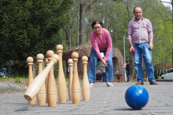 Mieszkanka gra w kręgle na świeżym powietrzu podczas grillowania.