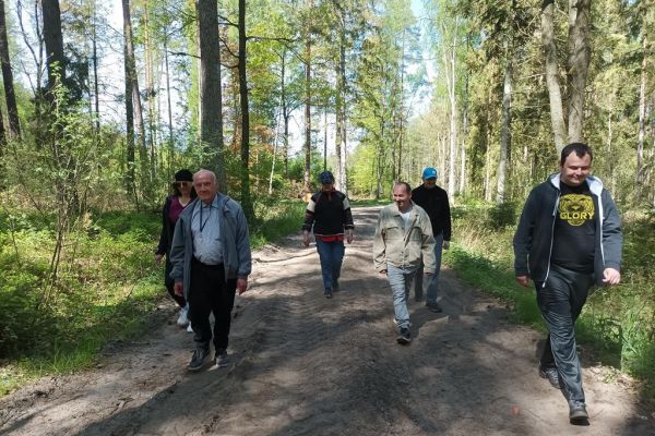 Mieszkańcy spaceruja przez las.