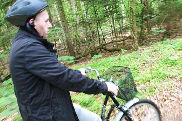 Mieszkaniec jedzie na rowerze przez las