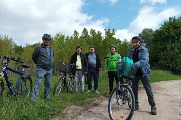 Mieszkańcy przystanęli przy swoich rowerach w polu.