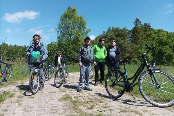 Mieszkańcy przystanęli przy swoich rowerach w polu.