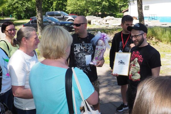 Mieszkańcy i terapeuci wręczają podziękowanie zespołowi Łydka Grubasa.