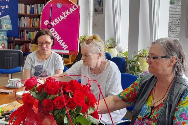 Mieszkanka czyta a inni uczestnicy DKK słuchają.