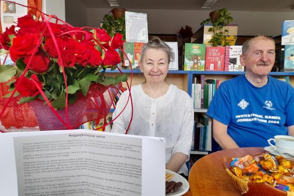 Dwoje uczestników DKK uśmiecha się podczas spotkania.