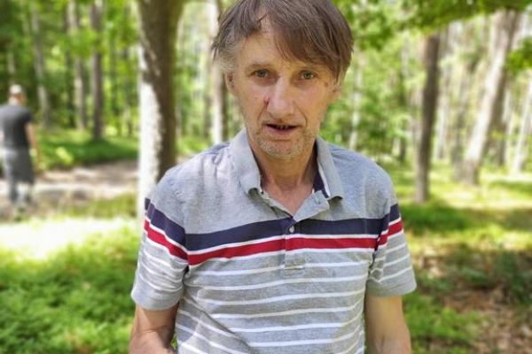 Mieszkaniec pokazuje zebrane jagody w miseczce.
