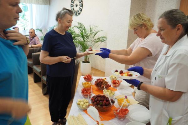 Mieszkańcy wybieraja owoce na szaszłyki.