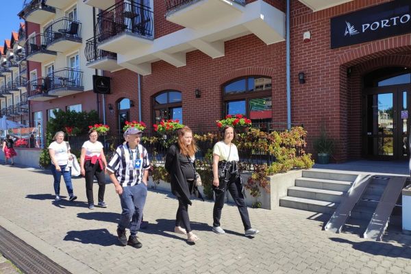 Mieszkańcy idą uliczką w Ustce.