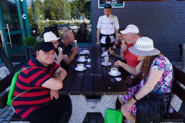 mieszkańcy jedzą lody i pija kawę w kawiarni w Licheniu.