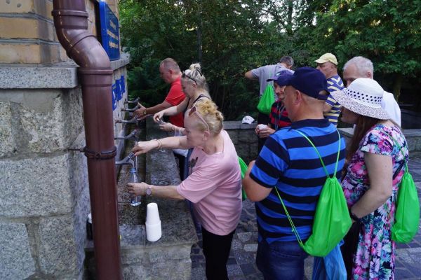 Mieszkańcy nalewają cudowna wodę ze źródełka w Licheniu.
