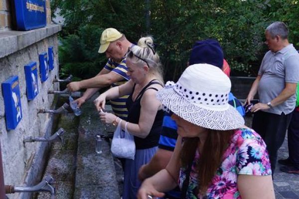 Mieszkańcy nalewają cudowna wodę ze źródełka w Licheniu.