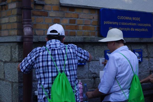 Mieszkańcy nalewają cudowna wodę ze źródełka w Licheniu.