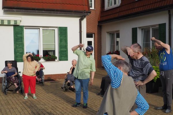 Mieszkańcy ćwiczą na świeżym powietrzu.