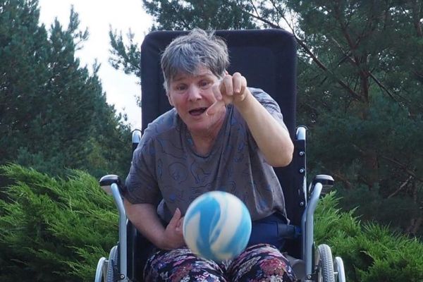 Mieszkanka rzuca piłką w kręgle.