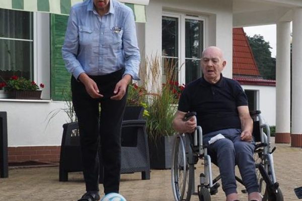 Mieszkaniec rzuca piłką w kręgle.