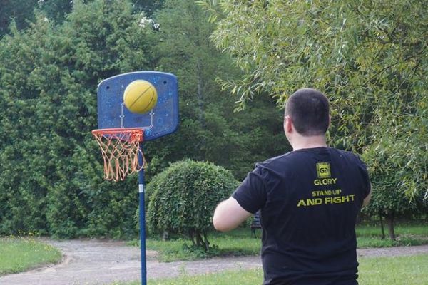 Mieszkaniec rzuca piłką do kosza od koszykówki.
