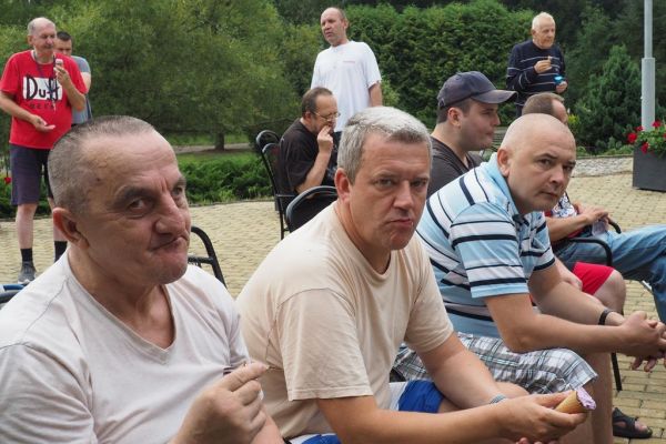 Mieszkańcy częstują się rozdawanymi lodami i je spożywają w upalny dzień siedząc na tarasie Domu.