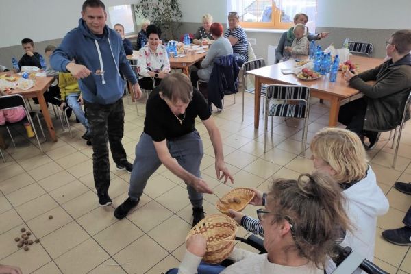 Uczestnicy pikniku podczas zabawy konkursowej przenoszenia orzechów na łyżce.