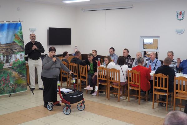 Mieszkanka śpiewa na świetlicy wiejskiej wraz z terapeutą.