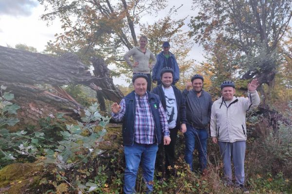 Mieszkańcy machaja do zdjęcia stojąc na pagórku.