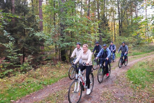 Mieszkańcy wraz z fizjioterapeutką jadą rowerami.