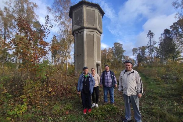 Mieszkańcy pozują do zdjęcia przy wieży.