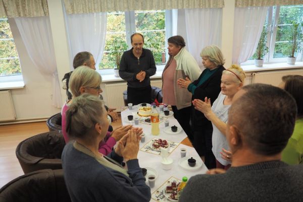 Mieszkańcy śpiewają stolat na stojąco przy stole soleniazantowi