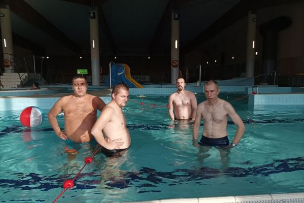 Czworo mieszkańców stoi w basenie.