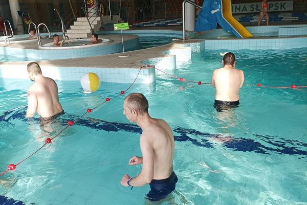 Troje mieszkańców stoi w basenie.