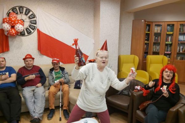 Mieszkańcy kibicują oglądając mecz polskiej drużyny piłkarskiej.