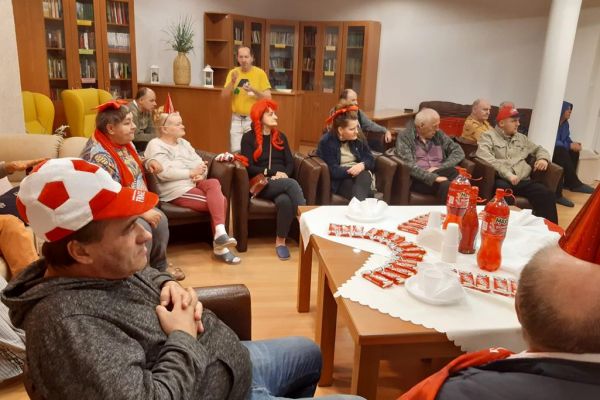 Mieszkańcy kibicują oglądając mecz polskiej drużyny piłkarskiej.