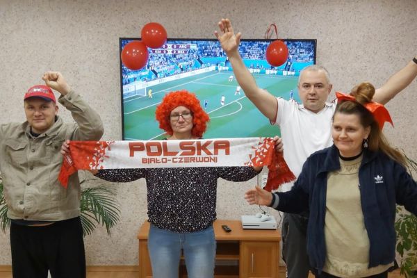 Mieszkańcy kibicują oglądając mecz polskiej drużyny piłkarskiej.