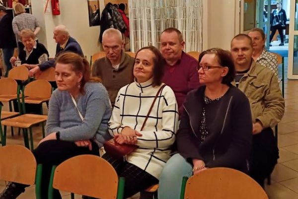 Mieszkańcy uczestniczą w spotkaniu autorskim.