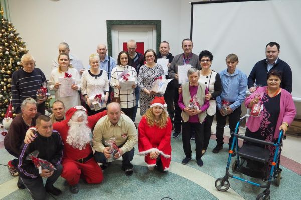 Zbiorowe zdjęcie nagrodzonych i wyróżnionych mieszkańców z Panią Dyrektor i dwoma Mikołajami.