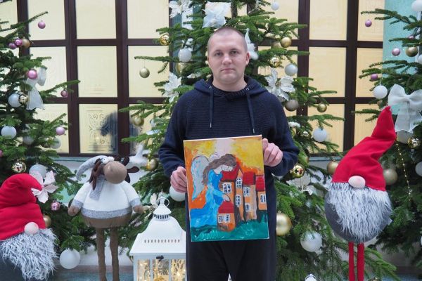 Mieszkaniec trzyma swój obraz.