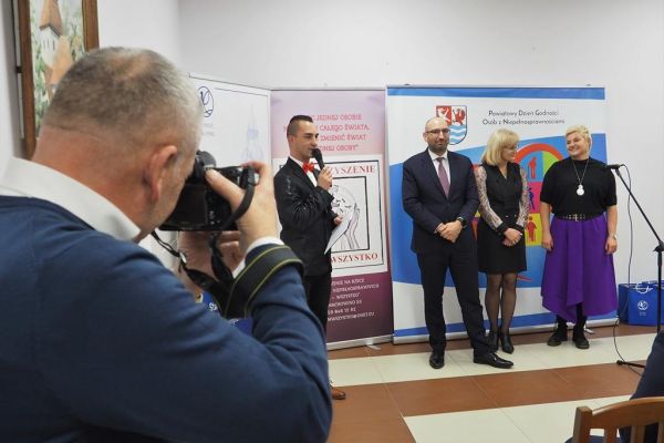 Na scenie stoi prowadzący spotkanie oraz Pan Starosta Powiatu Słupskiego, Dyrektorka PCPR w Słupsku i właścicielka Zakątka lawendowego w Machowinie.