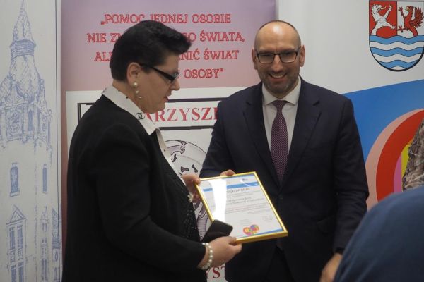 Mieszkanka odbiera nagrodę z rąk Pana Starosty Powiatu Słupskiego.