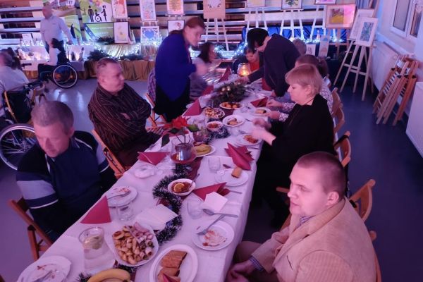 Mieszkańcy siedzą przy stole wigilijnym.