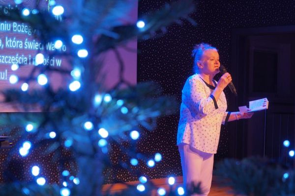 Mieszkanka czyta wiersz na scenie.