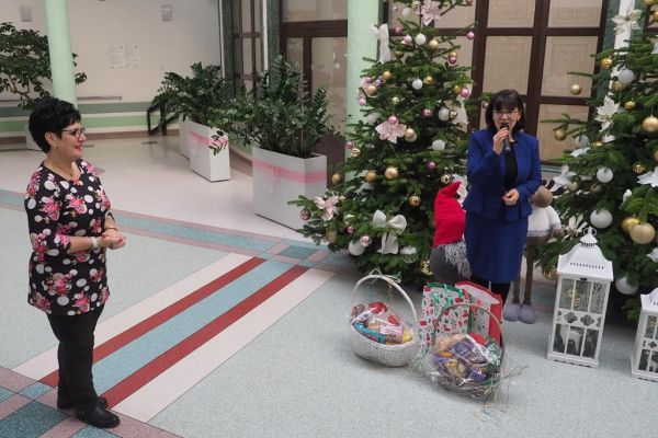 Pani Wójt składa życzenia zgromadzonym mieszkańcom na holu domu.