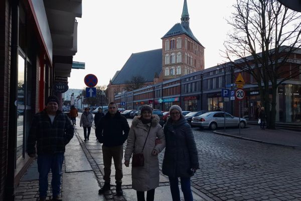 Czworo mieszkańców spaceruje ulicami w Kołobrzegu.