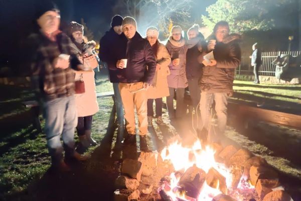Mieszkańcy wraz z uczestnikami przy ognisku zorganizowanym przy kościele w Rowach.